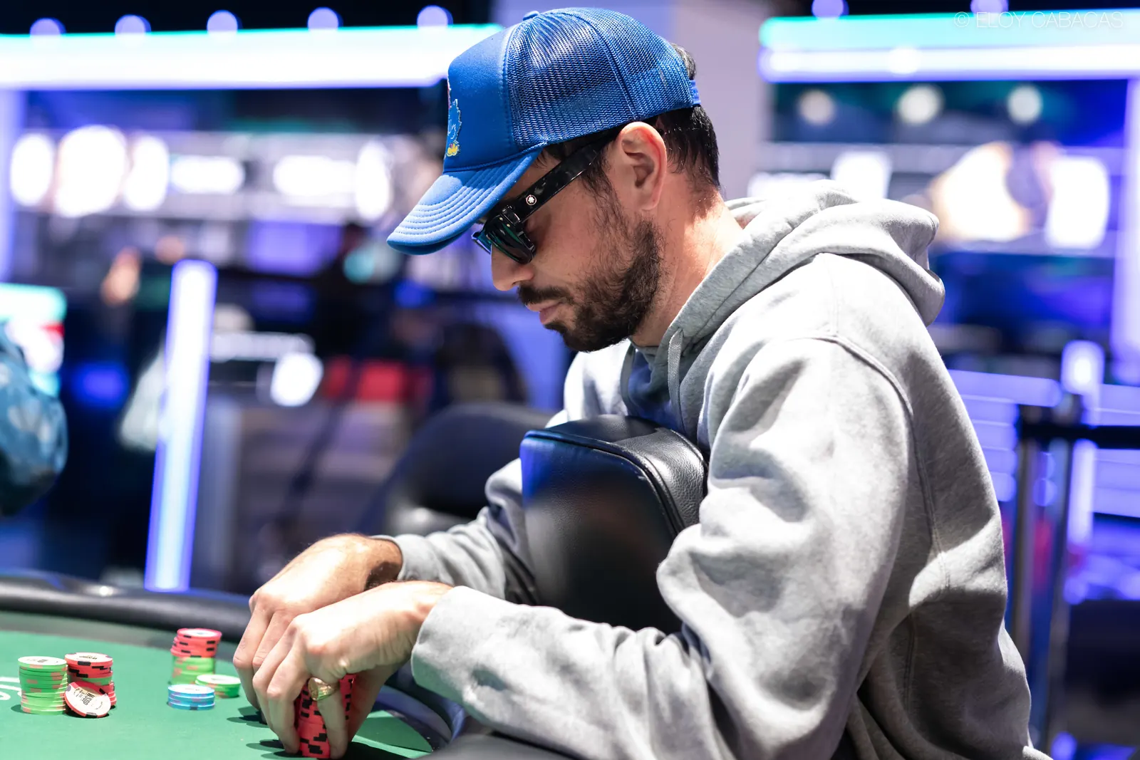 Nick Schulman, członek Poker Hall of Fame, siedzi przy stole pokerowym podczas turnieju World Series of Poker, skupiony na grze.