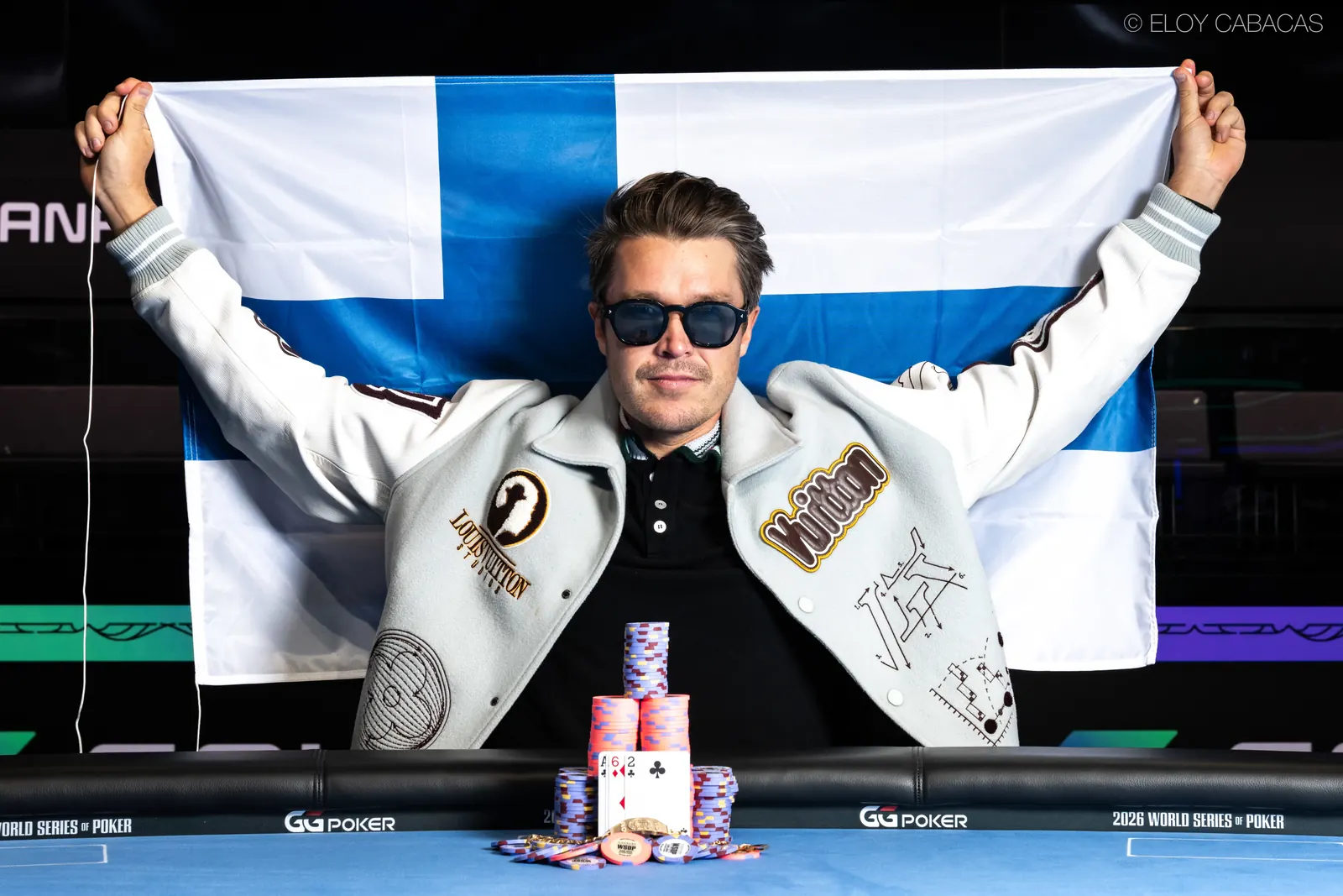 Eelis Parssinen pozuje do zdjęcia z bransoletą World Series of Poker i czekiem na 2,16 miliona dolarów.