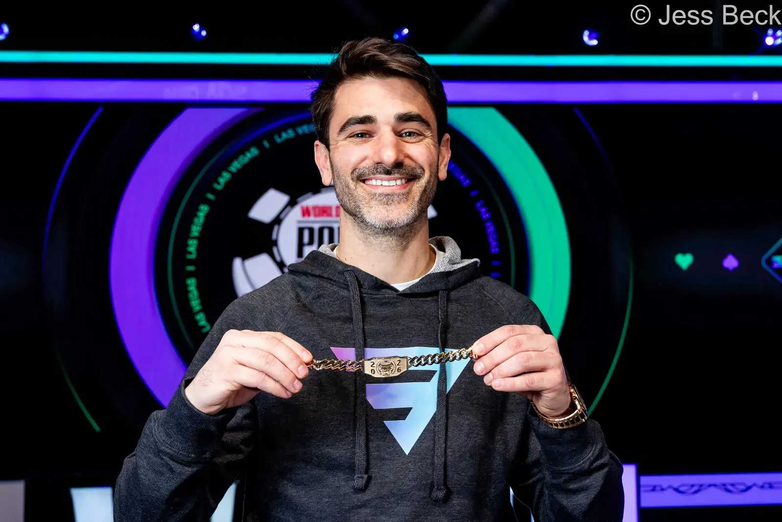Joseph Liberta, zwycięzca turnieju WSOP Milly Maker, prezentuje swój puchar i czeki z nagrodą pieniężną.