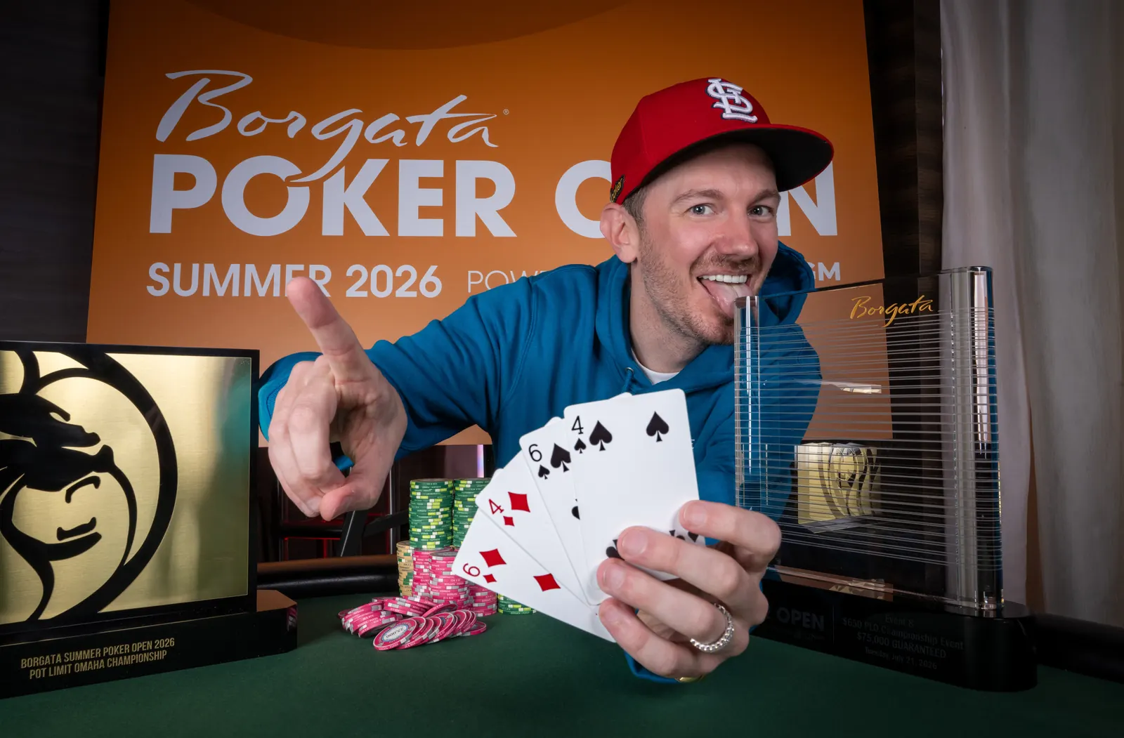 Brandon Mueller celebrando su victoria en un torneo de poker PLO con cartas de ases.