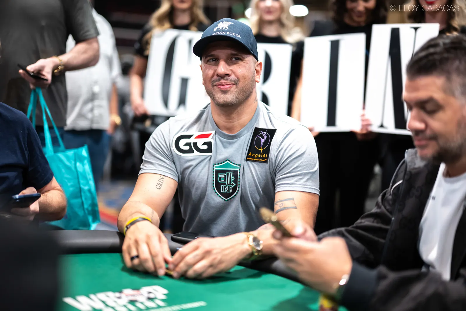 Michael Mizrachi, obrońca tytułu WSOP Main Event, siedzi przy stole turniejowym z żetonami przed sobą.