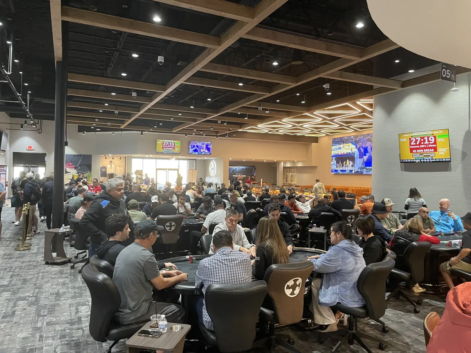 Interior del club de póker Texas Card House con mesas de póker y jugadores durante un torneo